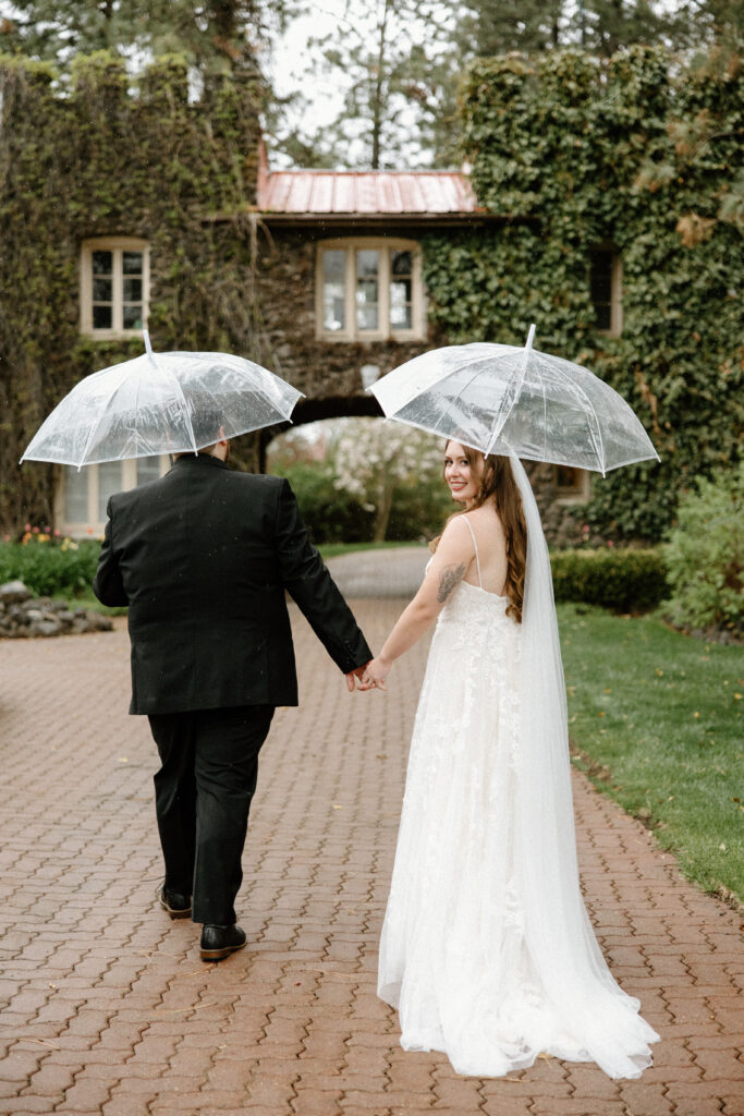 bride and groom walking in the rain at their Arbor Crest winery wedding.