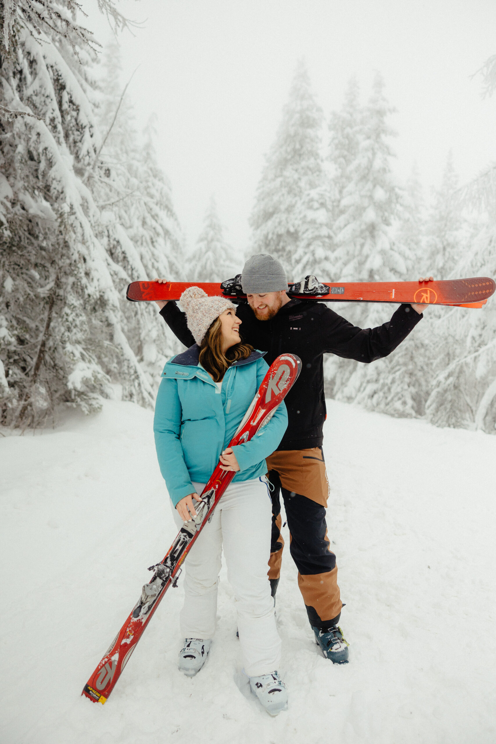 Couple holding skis during engagement photos at Mt Spokane