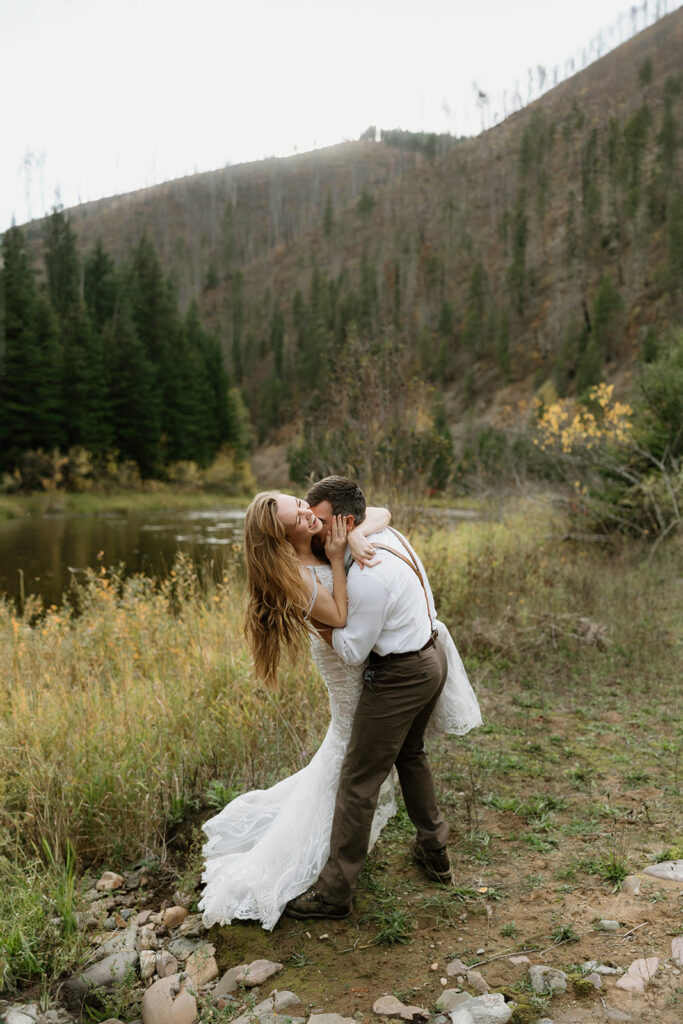 bride laughing as the groom kisses her neck