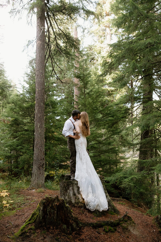 bride caressing groom in the forest during their elopement photos