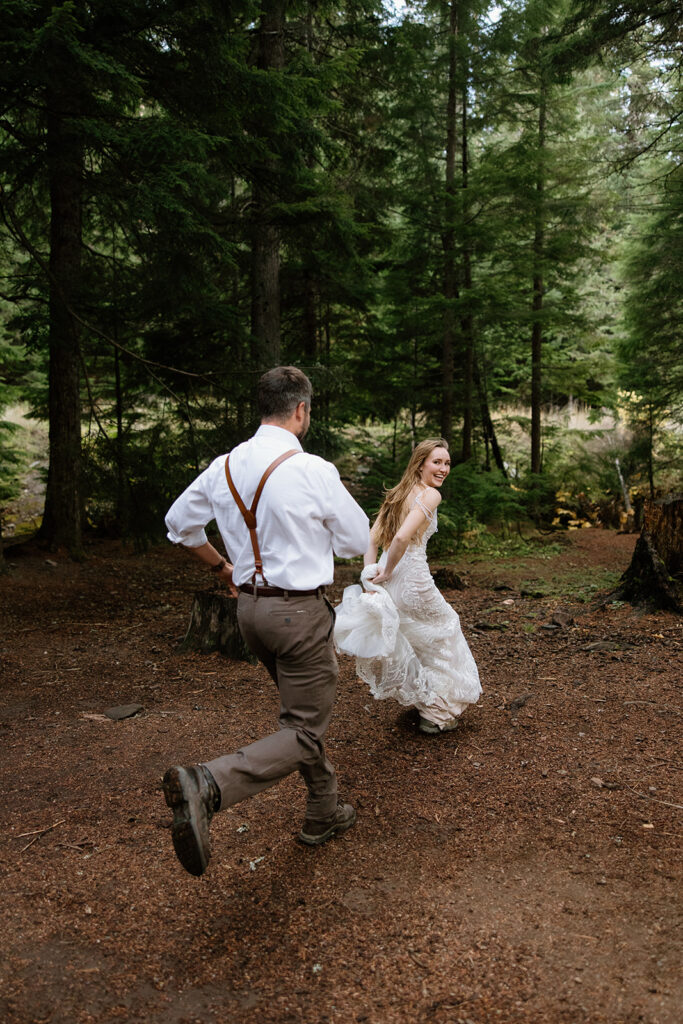 groom chasing his bride through the woods for elopement style photos