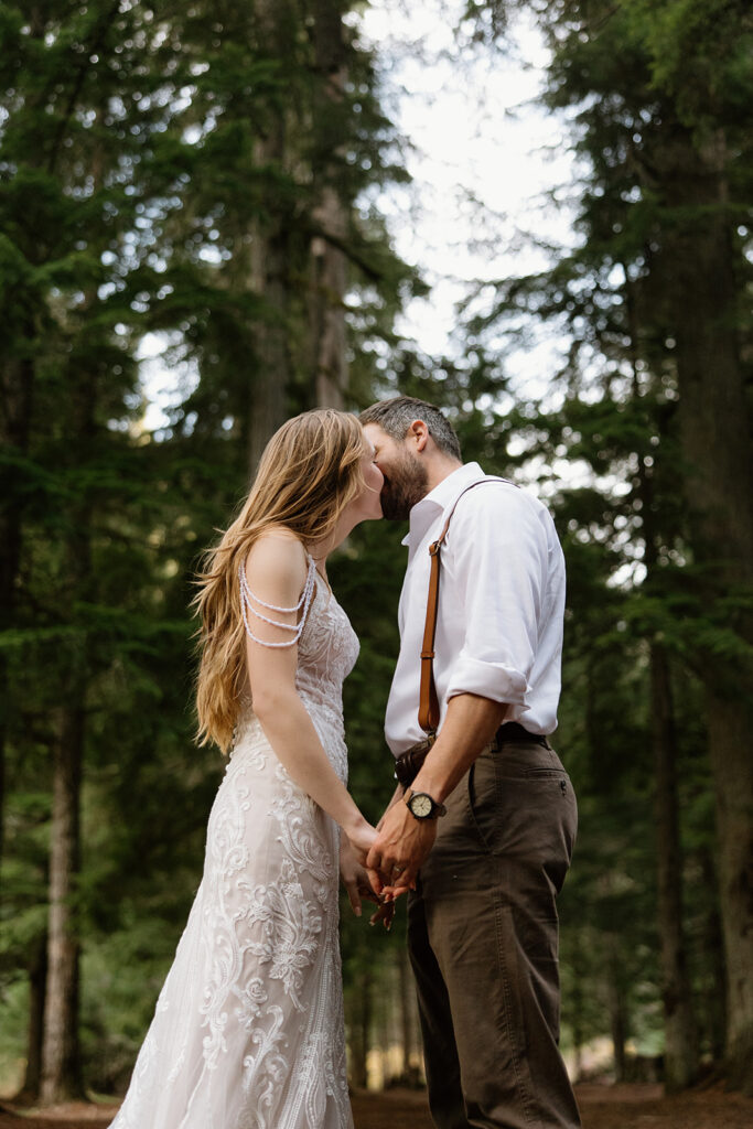 bride and groom sharing a kiss in the forest during elopement photos