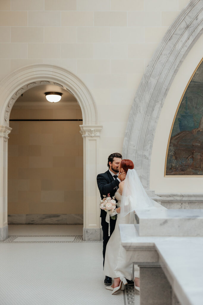 Bride and groom kissing in the rotunda of the Utah State Capitol 