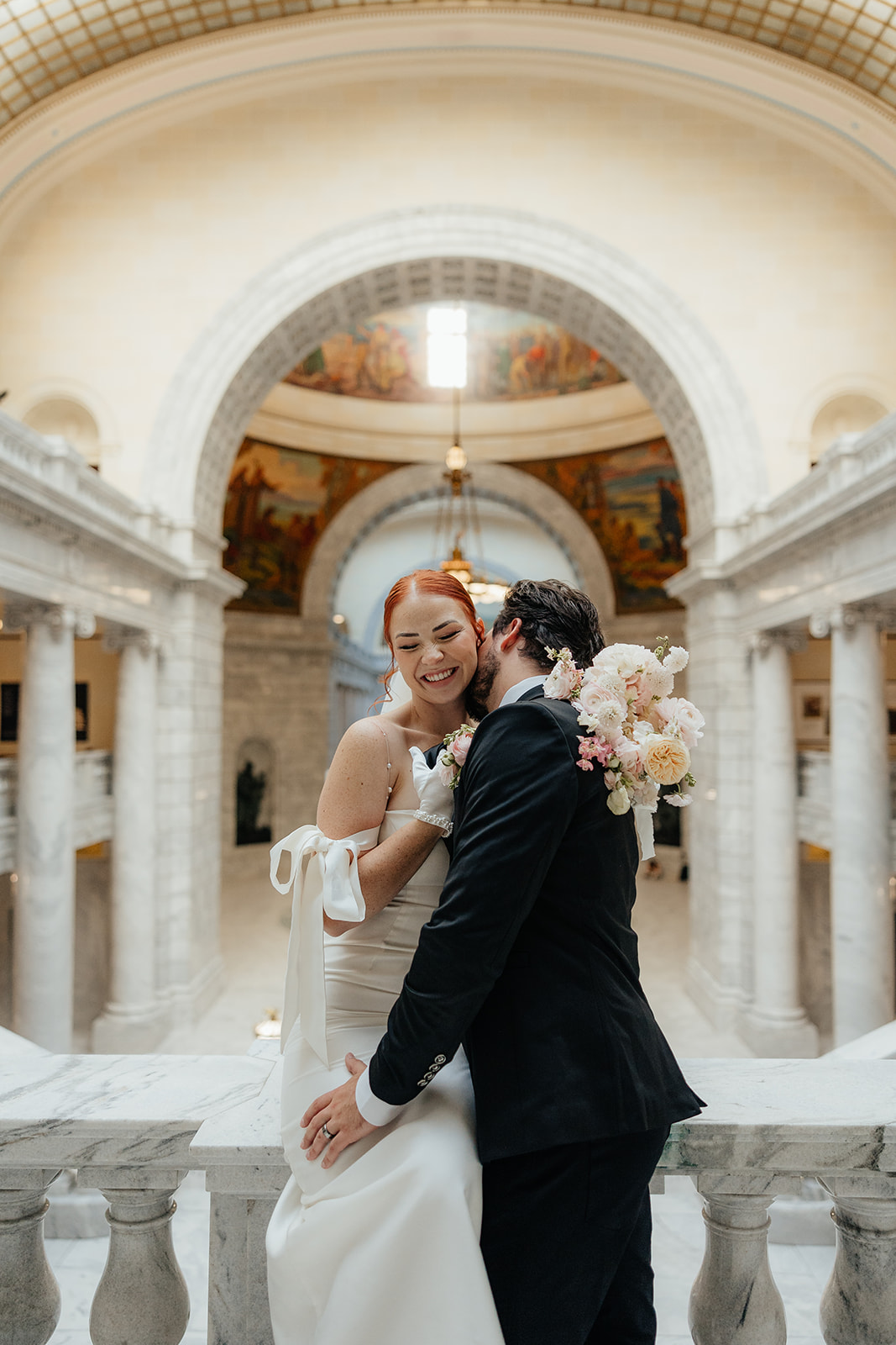 Bride and groom kissing in the rotunda of the Utah State Capitol